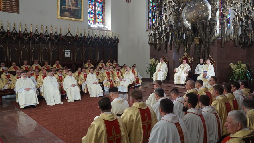 Neoprezbiterzy w prezbiterium z innymi kapłanami.